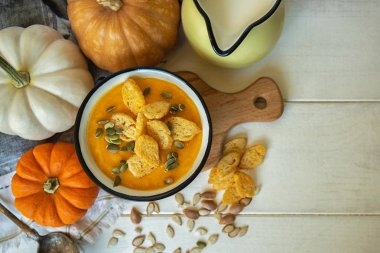 Ahşap arka plan üzerinde tohum ve kruton ile Sebze çorbası. Sağlıklı sonbahar vejetaryen yemekleri. Sonbahar pişirme hazırlığı. Kabak, kırmızı kırmızı biber, Şükran Günü tarifleri veya menü kartı için rustik arka plan havuç.