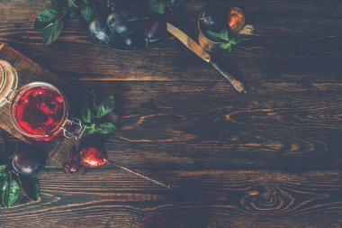 Masada lezzetli erik reçeli kavanoz uile kompozisyon. Tahta masada organik erikler. Taze organik meyve reçeli. Üst te. Kopyalama alanı.