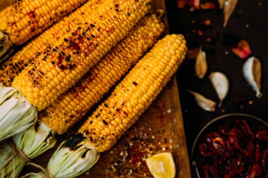 Baharat, sarımsak, limon, kırmızı biber ve peynir ile ızgara mısır koçanları. Meksika yemeği. Sağlıklı, organik, ev yapımı yiyecekler. Tonlu görüntü. Kopyalama alanı ile düz yatıyordu.