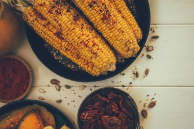 Sağlıklı bir aşçılık geçmişi var. Şükran Günü yemeği ızgarada kızarttı. Düz mısır koçanı, baharat ve taze çiftlik sebzesi ahşap masa..