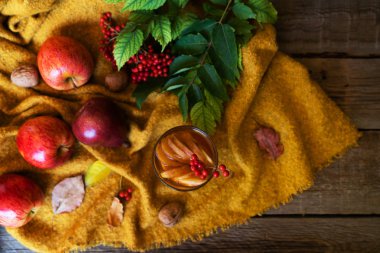 Sonbahar yaprakları ve ahşap masada bir fincan çay. Sonbahar modunda. Tonlanmış görüntü. Üst görünüm, alanı kopyala.