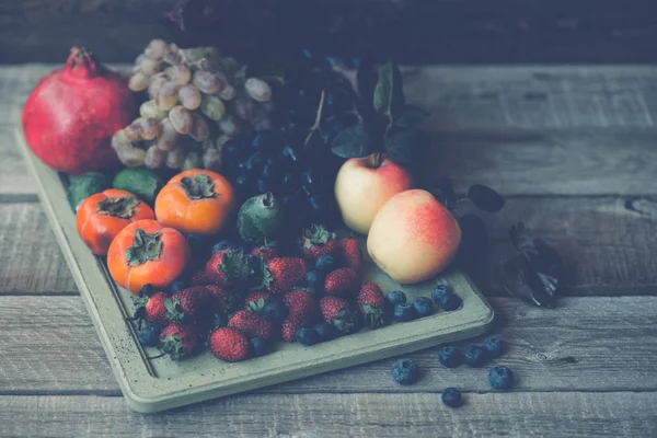 Regenbogenfrüchte Hintergrund Erdbeeren Blaubeeren Äpfel Trauben Kaki Granatapfel Auf Dunklem — Stockfoto