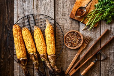 Koyu kırsal arka planda peynirli ve baharatlı mısır. Sonbahar yemekleri geçmişi. Yazın ya da sonbaharda fast food. Tonlanmış görüntü. Düz yatıyordu.
