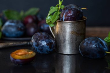 Siyah taş tabakta yaprakları olan erikler. Rustik yemek geçmişi. Taze organik meyveler. Sağlıklı yiyecekler. Tonlu görüntü. Metniniz için boş alan.