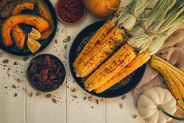 Yaz ya da sonbahar vejetaryen yemeği ya da atıştırmalık. Beyaz kırsal arka planda füme deniz tuzu ve kişniş ile ızgara tatlı mısır, üst manzara. Vejetaryen, sağlıklı, alkali diyet konsepti.