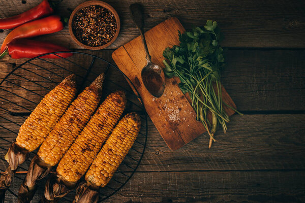 Summer or autumn food background. Ideas for barbecue and grill parties. Grilled corn, cheese on a dark wooden table. Healthy food, organic, bio, homemade food. Top view.