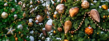Noel ve Yeni Yıl tatili geçmişi. Açık havada süslenmiş altın renkli Noel Ağacı. Noel sabahı. Kış tatillerinde sokak dekorasyonu.