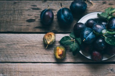 Rustik mutfak masasında olgun sulu erik ile Colander. Sağlıklı vejetaryen yemekleri. Biyo, organik yemek. Üst te. Kopyalama alanı.
