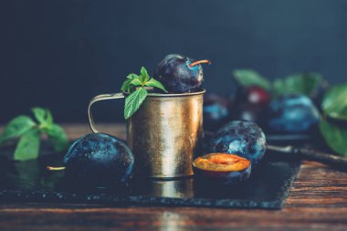 Yaprak ve su damlaları ile Erik. Sonbahar hasadı. Biyo, organik gıda. Sağlıklı vejetaryen yemekleri. Taze organik meyveler. Yemek geçmişi. Tonlu görüntü.