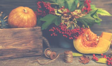 Sonbahar rustik kompozisyon. Kabaklar, vintage kutu, kurutulmuş yapraklar, koyu ahşap arka plan üzerinde kırmızı meyveler. Sonbahar, sonbahar, cadılar bayramı konsepti. Tonlu görüntü. Kopya alanı. Seçici odaklama.