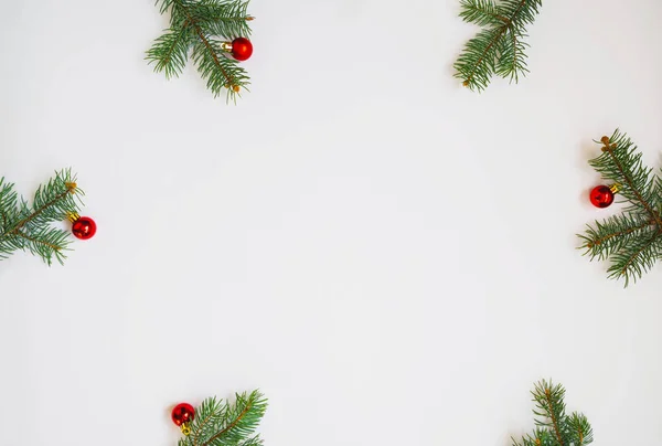 白い背景に新鮮なモミの枝と赤い泡で作られたクリスマスフレーム 冬のコンセプト — ストック写真