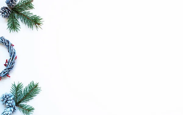 クリスマスの国境だパステルグレーの背景にリース 赤い果実 モミの枝や松のコーン クリスマス 新年のコンセプト フラットレイアウト トップビュー コピースペース — ストック写真