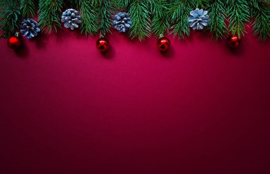 Noel kompozisyonu. Taze köknar ağacı dalları, kırmızı arka planda süslemeler. Noel, kış, yeni yıl konsepti. Düz konum, üst görünüm, kopyalama alanı.