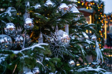 Noel arkaplanı. Gümüş renkli süslemeleri olan Noel Ağacı. Noel sabahı. Kış tatillerinde sokak dekorasyonu.