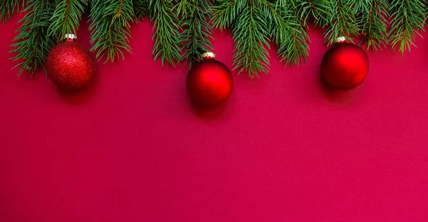 テキストのコピースペースを持つ赤い背景にクリスマス休暇の組成物 赤い背景にクリスマスの赤い装飾 モミの木の枝 フラットレイアウト トップビュー コピースペース — ストック写真