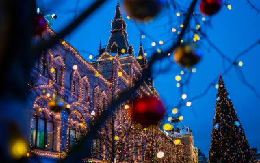 Ağaç gövdesindeki Noel ışıkları, yakın plan. Bulanık arka sokak, yılbaşı ışıklarıyla. Noel ve Yeni Yıl tatili geçmişi. Klasik renk tonu. Metnin için boşluk kopyala.