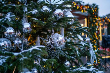 Noel arkaplanı. Gümüş renkli süslemeleri olan Noel Ağacı. Noel sabahı. Kış tatillerinde sokak dekorasyonu.