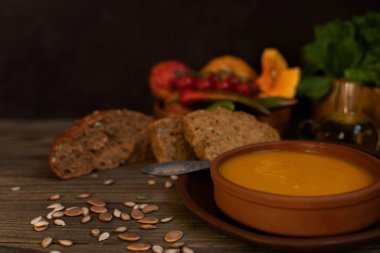 Sebze krema çorbası ve malzemeler. Sağlıklı beslenme veya vejetaryen gıda kavramı. Diyet vejetaryen kabak kreması çorba püresi, koyu kahverengi ahşap masa üzerinde. Kopya alanı. Tonlu görüntü. Yumuşak odaklama.