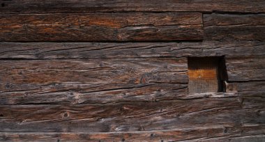 İsviçre Alpleri 'ndeki eski ahşap ahır yıpranmış. Ahşap ahşap duvar dokusu arka plan. Doğal arka plan olarak kullanılır. Klasik tonlu. Boş şablon.