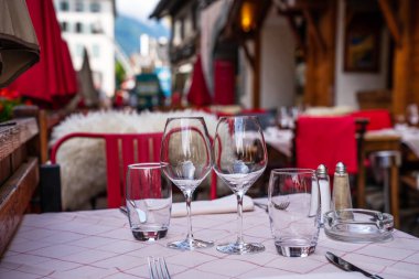 Cozy street with tables of cafe old town street in Chamonix village, France. Architecture and landmark. Cozy cityscape. Typical view of the street with tables of cafe in Chamonix. clipart