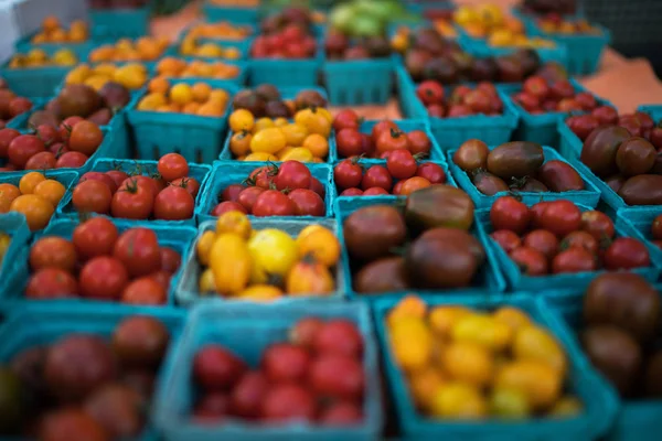 農家の市場でカウンターに有機赤トマトのパイントバスケット 地元の農家市場で販売中の新鮮な食材 — ストック写真