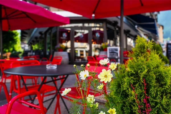 Cozy street with tables of cafe old town street in Chamonix village, France. Architecture and landmark. Cozy cityscape. Typical view of the street with tables of cafe in Chamonix.