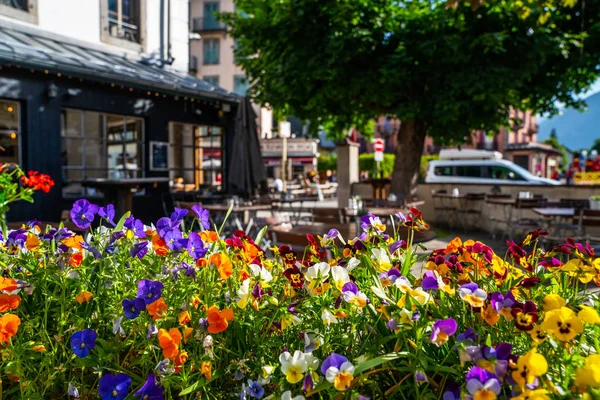 Cozy street with tables of cafe old town street in Chamonix village, France. Architecture and landmark. Cozy cityscape. Typical view of the street with tables of cafe in Chamonix.