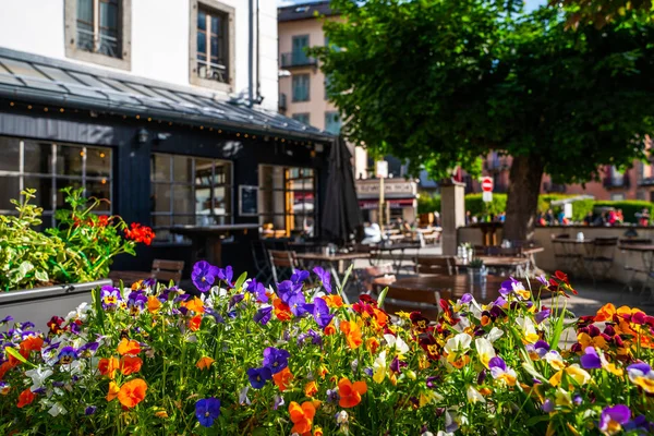 Cozy street with tables of cafe old town street in Chamonix village, France. Architecture and landmark. Cozy cityscape. Typical view of the street with tables of cafe in Chamonix.