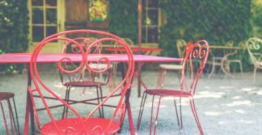 Arka bahçe avlusu. Antika demir mobilyalar, pejmürde bir dış görünüş. Yuvarlak eski masa ve dışarıda eski Fransız evinde sandalyeler. Klasik stil.