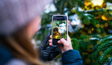 Noel ağacı ışığından Bokeh 'e el ele tutuşan akıllı telefon tasarım ve noel konsepti için kullanılabilir..