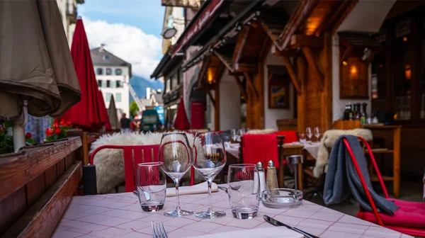 Cozy street with tables of cafe old town street in Chamonix village, France. Architecture and landmark. Cozy cityscape. Typical view of the street with tables of cafe in Chamonix.