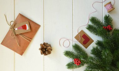 Noel tatili geçmişi. Çam ağacı dalları, kırmızı böğürtlenler, baharatlar ve kırsal ahşap masada hediyeler. Kış Xmas bayramı teması. Düz konum, üst görünüm, kopyalama alanı.