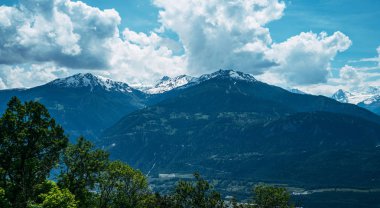 Dağ sırası. İsviçre dağlarındaki güzel dağlık çayır manzarası. Otlaklar, yamaçlardaki çayırlar ve karlı dağlarda.