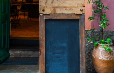 Restoran girişinin önündeki tahta tahta tahta tahta. Boş yeri olan eski ahşap boş ilan panosu. Açık hava reklam afişi ya da reklam panosu için boş ilan panosu.