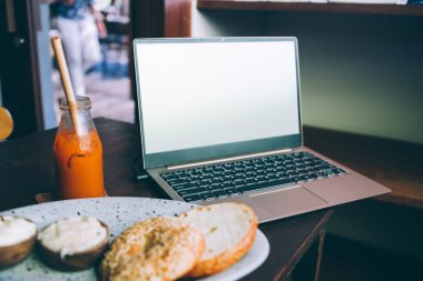 Masada boş ekran yiyeceği ve smoothie olan dizüstü bilgisayar