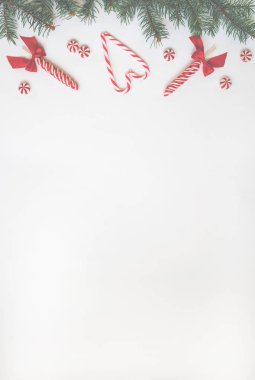 Yaratıcı asgari Noel sanatı. Beyaz arka planda Noel şekerleriyle yapılmış bir sınır. Düz yatıyordu. Uzayı kopyala En düşük bileşim.