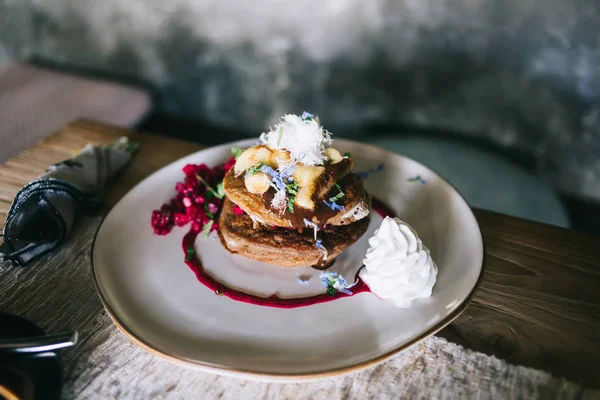 Deliciosos panqueques con copos de coco y crema batida blanca vertida con jarabe dulce — Foto de Stock