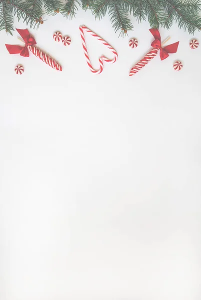 Creative minimal Christmas art. Border made with Christmas candies on white background. Flat lay. Copy space. Minimal composition.