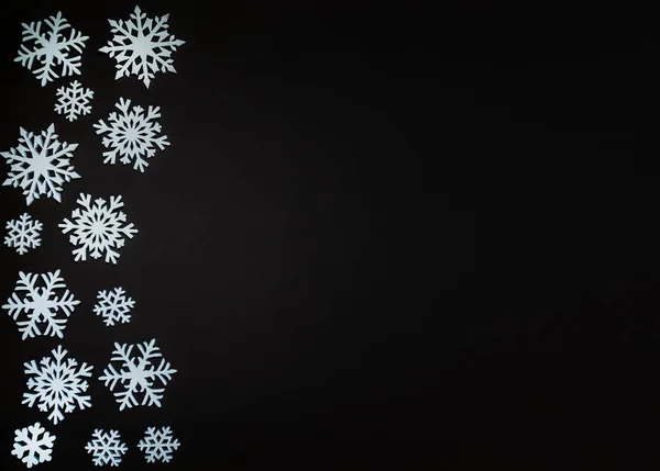 Christmas or winter composition. Frame made of snowflakes on dark background. Christmas, winter, new year concept. Flat lay, top view, copy space.