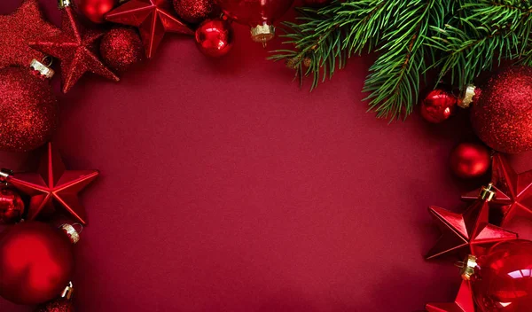 赤いクリスマスボールとコピースペースと赤い背景の星の装飾 新年の挨拶カード テキストのコピースペースを持つトップビュー — ストック写真