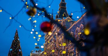 Ağaç gövdesindeki Noel ışıkları, yakın plan. Bulanık arka sokak, yılbaşı ışıklarıyla. Noel ve Yeni Yıl tatili geçmişi. Klasik renk tonu. Metnin için boşluk kopyala.