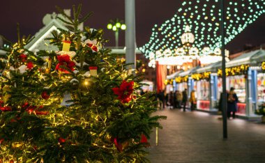 Noel süslemeleri olan şehir caddesi. Xmas ışıkları ve sokakta yürüyen insanlar. Arka plan bulanık. Yeni Yıl Kutlama Konsepti.