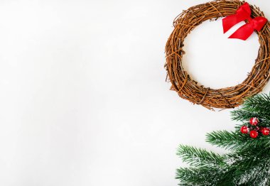 Noel ağacı dallarından yapılmış, çelenkli ve kırmızı süslemeli yaratıcı bir düzen. Düz konum, metin için boşluk kopyala. Doğa Yeni Yıl Konsepti.
