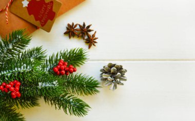 Noel tatili geçmişi. Çam ağacı dalları, kırmızı böğürtlenler, baharatlar ve kırsal ahşap masada hediyeler. Kış Xmas bayramı teması. Düz konum, üst görünüm, kopyalama alanı.