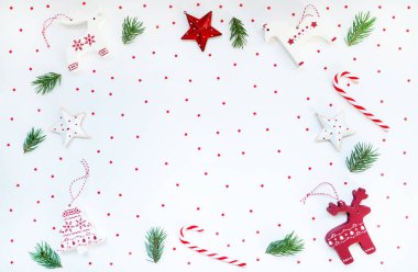 Kırmızı ve beyaz süslemeli Noel çerçevesi, eski tahta oyuncaklar, köknar dalları, pastel arka planda şeker kamışı. Noel, kış, yeni yıl konsepti. Metin için kopyalama alanı olan üst görünüm.