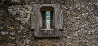 Metal dövmeli eski bir ortaçağ taş kale duvarı. Antik taş duvarda yıpranma ve yıkım izleri var..
