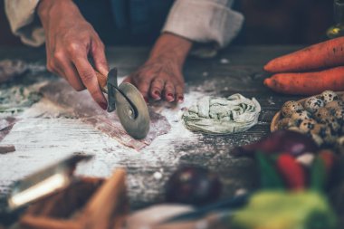 Peynirli İtalyan makarnası ve sebzeli şef manzarası. Tahta tahtada İtalyan usulü makarna ve koyu ahşap arka planda makarna pişirmek için malzemeler..