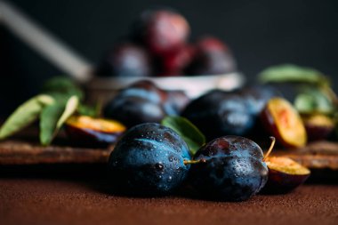 Bahçe erikleri masada. Yaprakları ile taze erik kapatın. Erik yaz veya sonbahar hasadı. Tonlu görüntü. Seçici odaklama.