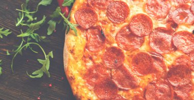 Tahta masada pizza var. Pizzacıların tanıtım posteri, şablon. Esmer arka planda geleneksel İtalyan pizzası. Pizza menüsü. Yukarıdan bak. Metin için boşluk.