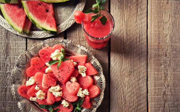 Fresh summer watermelon salad with feta cheese, arugula, onions on rustic background.